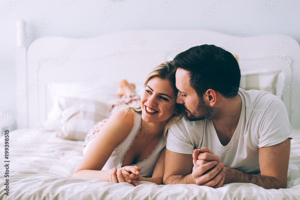 Portrait of young loving couple in bedroom