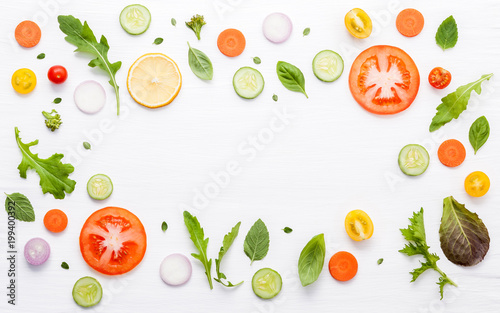 Food pattern with raw ingredients of salad. Various vegetables lettuce leaves, cucumbers, tomatoes, carrots, broccoli, onion and lemon flat lay on white background.