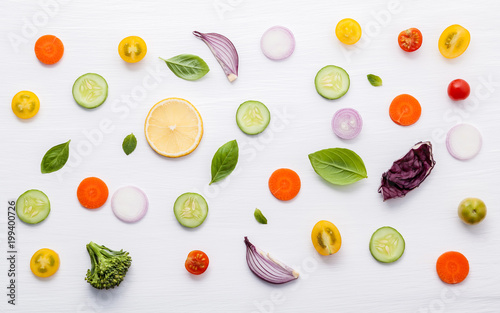 Fototapeta Naklejka Na Ścianę i Meble -  Food pattern with raw ingredients of salad. Various vegetables lettuce leaves, cucumbers, tomatoes, carrots, broccoli, onion and lemon flat lay on white background.