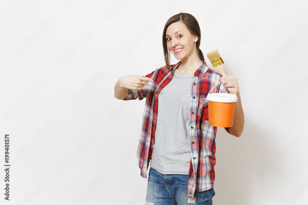 Young smiling beautiful woman pointing index finger on paint brush and paint bucket isolated on white background. Instruments, accessories, tools for renovation apartment room. Repair home concept. Young smiling beautiful woman pointing index finger on paint brush and paint bucket isolated on white background. Instruments, accessories, tools for renovation apartment room. Repair home concept.