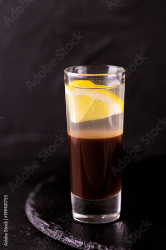 Alcoholic cocktail silver bullet with gin, coffee liqueur and lemon.