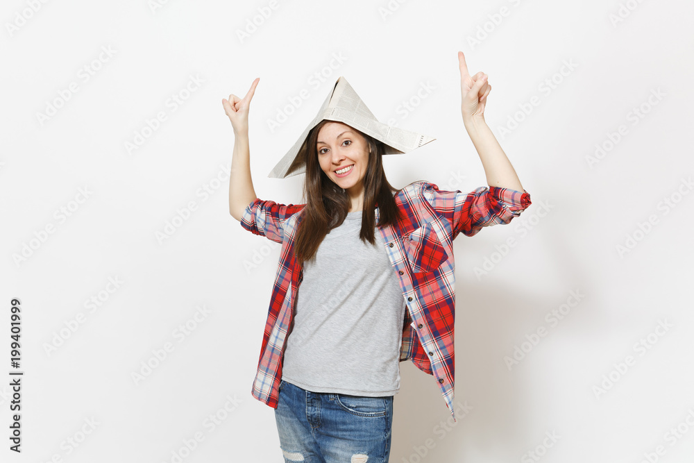 Young smiling beautiful woman in newspaper hat pointing index fingers up on copy space isolated on white background. Accessories for renovation apartment room. Repair home concept. Advertising area. Young smiling beautiful woman in newspaper hat pointing index fingers up on copy space isolated on white background. Accessories for renovation apartment room. Repair home concept. Advertising area.