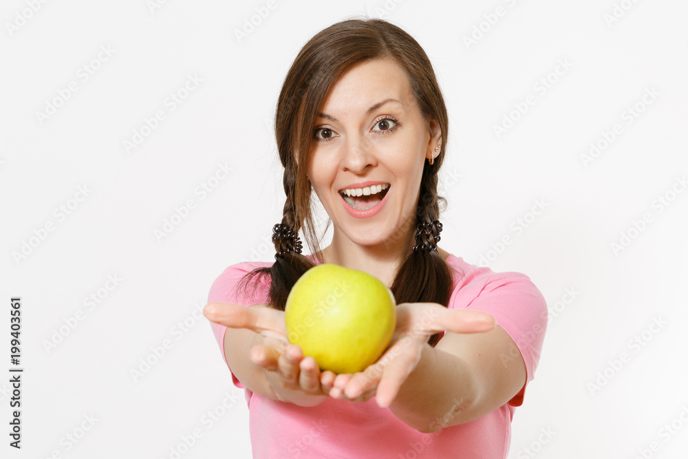 Beautiful smiling young woman with pigtails in pink t-shirt holding in hands green apple isolated on white background. Proper nutrition, dieting concept. Copy space for advertisement. Advertising area Beautiful smiling young woman with pigtails in pink t-shirt holding in hands green apple isolated on white background. Proper nutrition, dieting concept. Copy space for advertisement. Advertising area