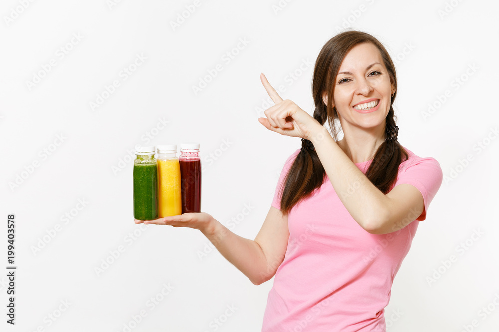 Fun woman holds row of green, red, yellow detox smoothies in bottles isolated on white background. Proper nutrition, vegetarian drink, healthy lifestyle, dieting concept. Copy space for advertisement. Fun woman holds row of green, red, yellow detox smoothies in bottles isolated on white background. Proper nutrition, vegetarian drink, healthy lifestyle, dieting concept. Copy space for advertisement.