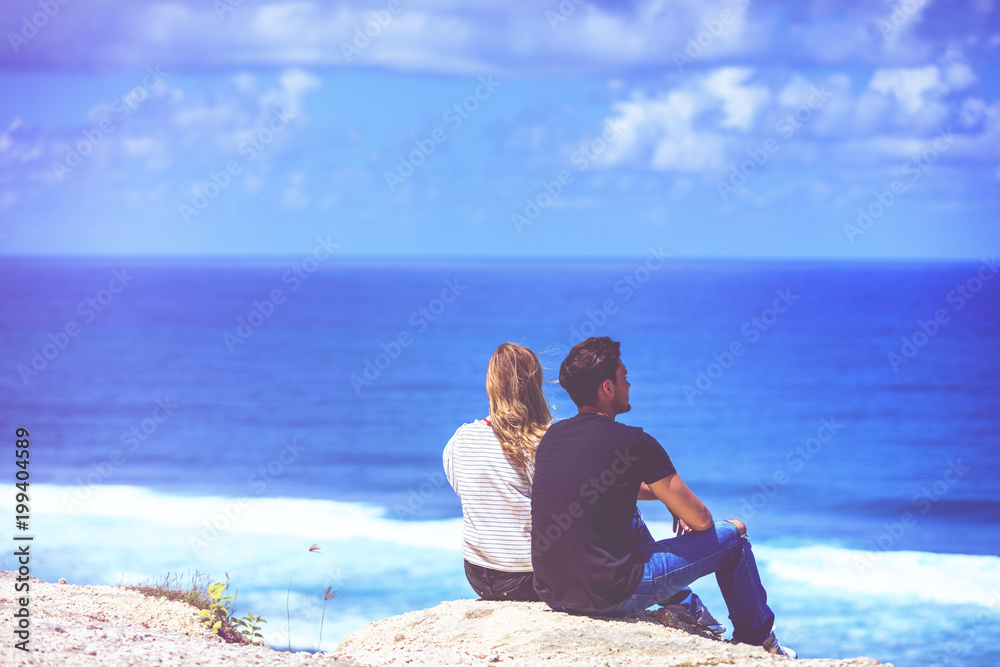 Couple looking at a tropical ocean / sea scenery.