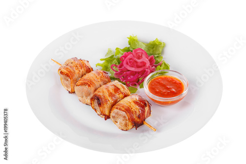 Shish kebab, beef, lamb, pork, chicken in bacon grilled meat, barbecue, without garnish on a plate, isolated on white background. Marinated onion, ketchup, tomato red sauce. Side view For the menu