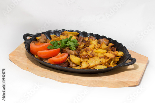 potatoes fried meat in a frying pan on a tree on a white background