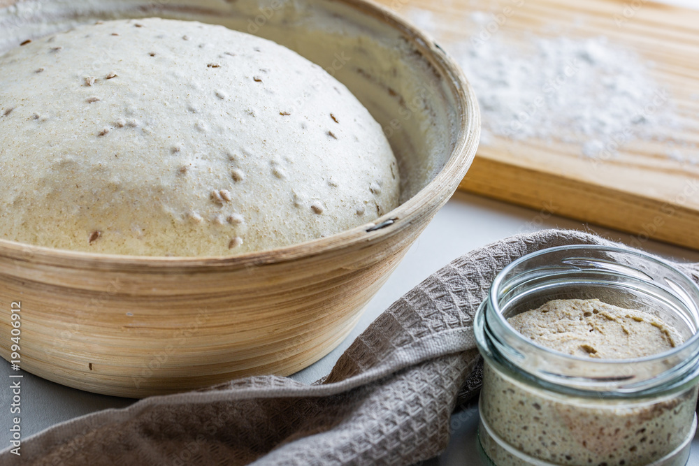 Dough with natural leaven with flax seeds in a rattan basket. The concept of a healthy diet. The style of life. Dough with natural leaven with flax seeds in a rattan basket. The concept of a healthy diet. The style of life.