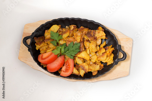 potatoes fried meat in a frying pan on a tree on a white background