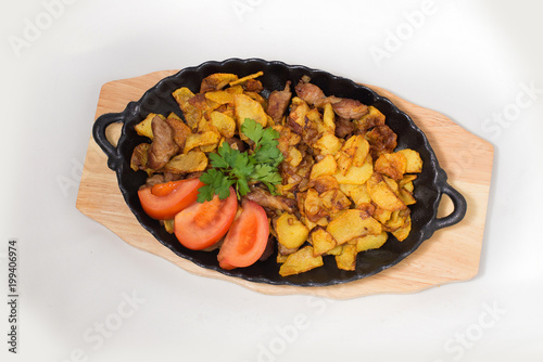 potatoes fried meat in a frying pan on a tree on a white background