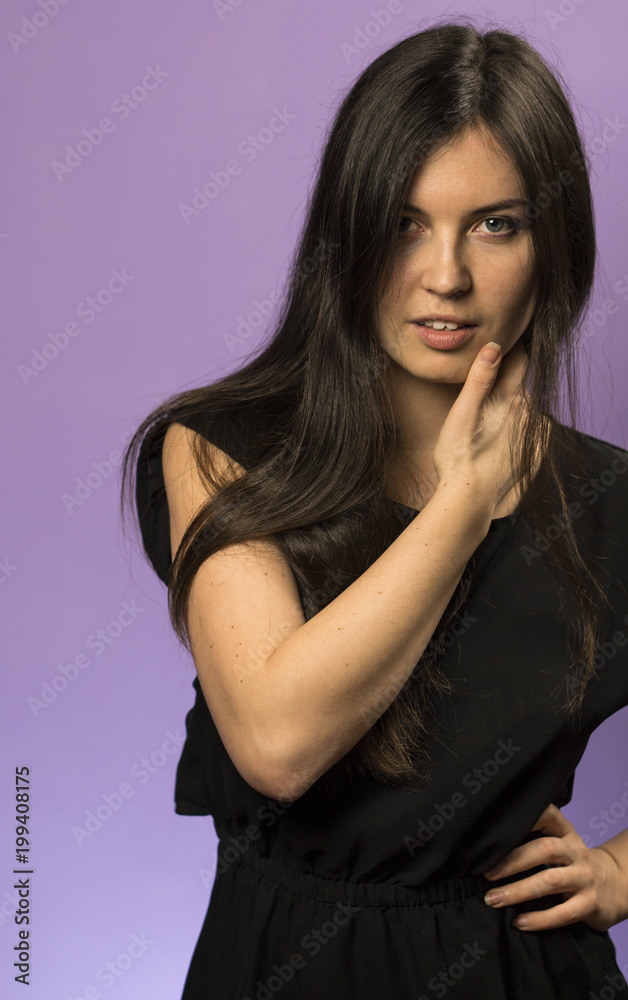 Portrait of a Charming Brunette girl on a Purple Background Portrait of a Charming Brunette girl on a Purple Background