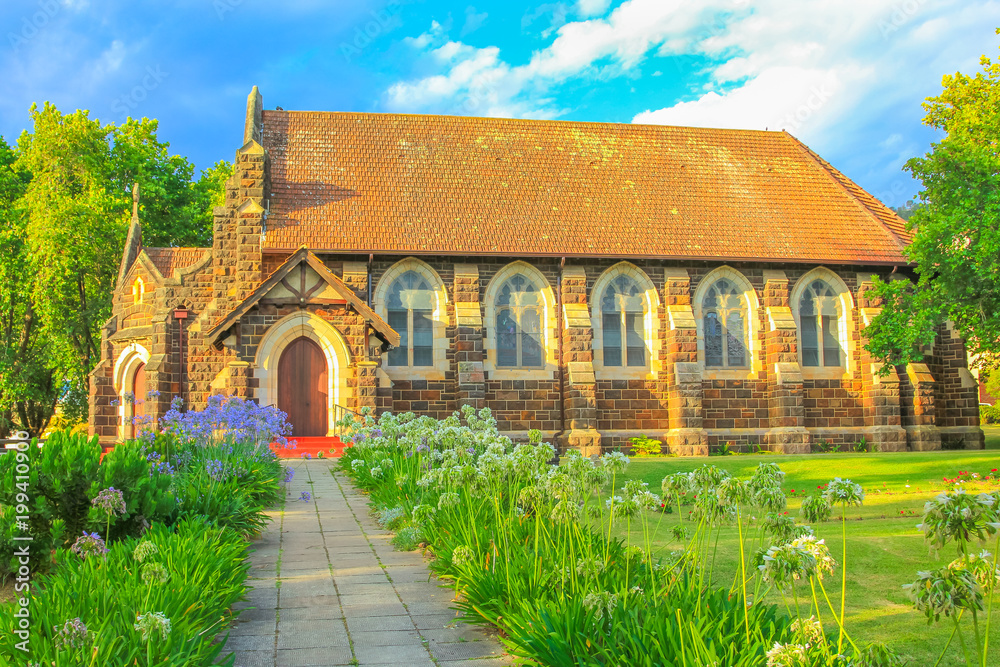 St. Georges Anglican Church and flowered garden in Knysna, city on the Garden Route in Western Cape, South Africa. The historic Church as built in 1855. Sunset shot. Side view. St. Georges Anglican Church and flowered garden in Knysna, city on the Garden Route in Western Cape, South Africa. The historic Church as built in 1855. Sunset shot. Side view.