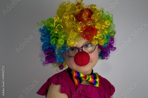 Little girl in clown costume .Little girl with glasses in colorful clown costume.