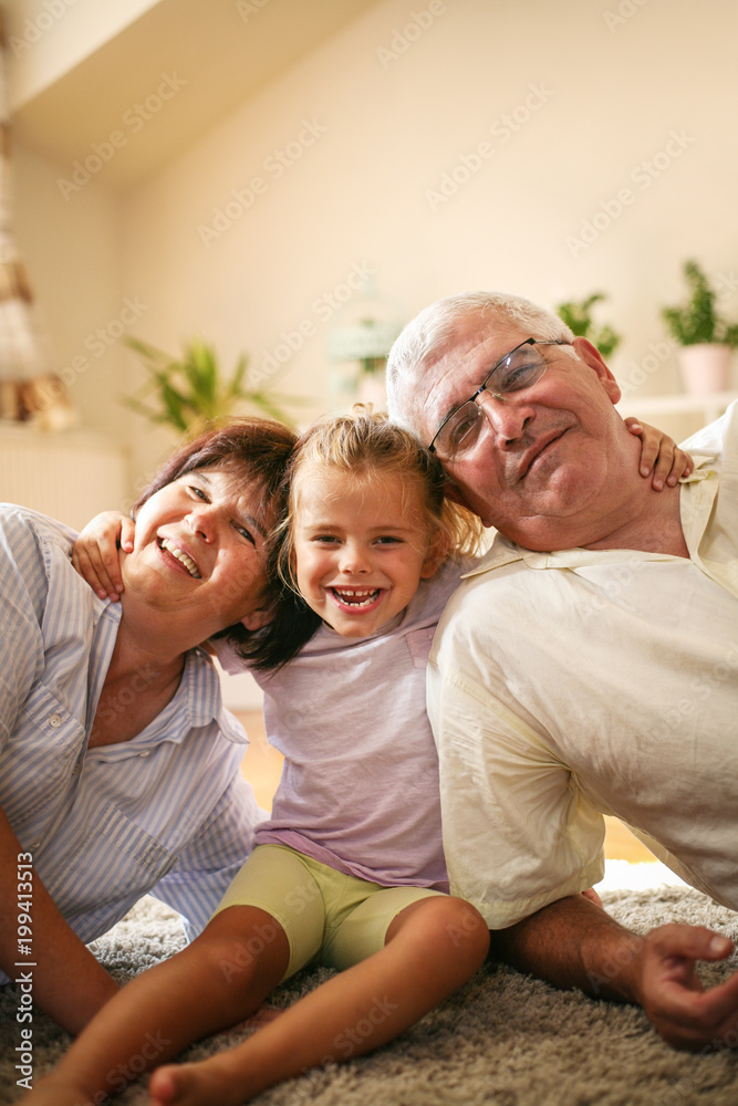 Happy family. Grandparents with granddaughter at home.