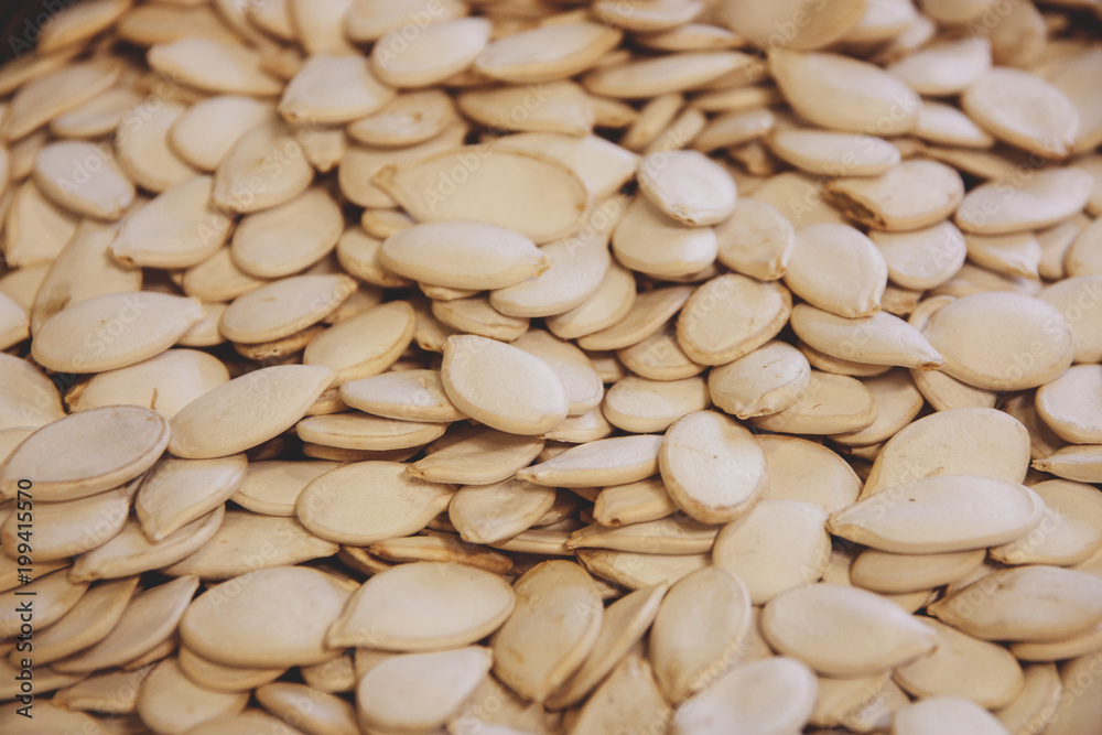 white pumpkin seeds uncooked in shop window close-up view from above