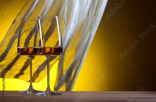 Glasses of white wine on a yellow background. © Igor Normann