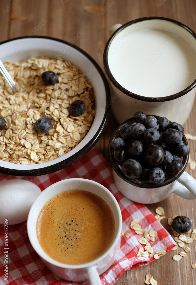 Healthy eating, food and diet concept - tasty oatmeal with berries and a mug of milk and a cup of coffee.Top view. Healthy eating, food and diet concept - tasty oatmeal with berries and a mug of milk and a cup of coffee.Top view.