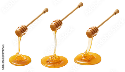 Tablou canvas Set of wooden dippers with dripping honey isolated on white background