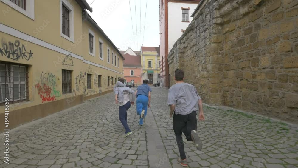 Three traceurs running and jumping on a street Three traceurs running and jumping on a street