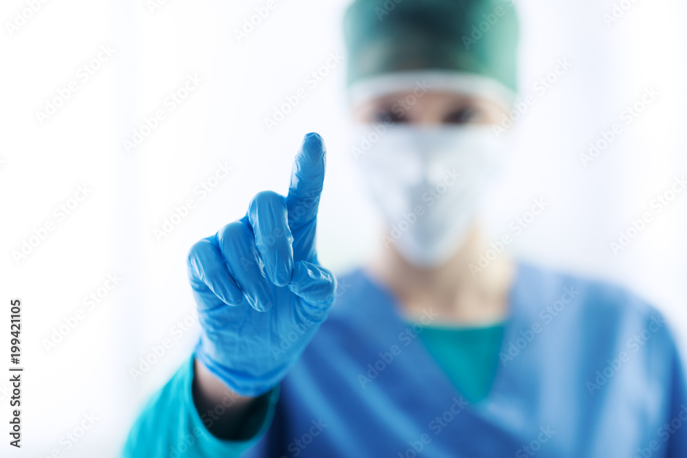 Female surgeon using a touch screen interface Female surgeon using a touch screen interface