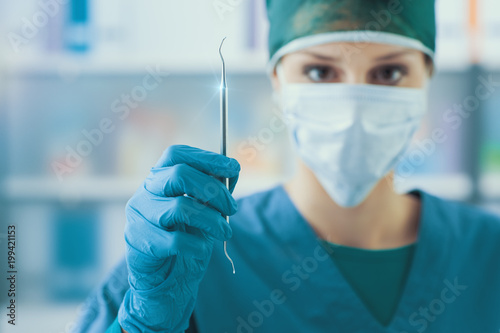 Female dentist holding a scaler