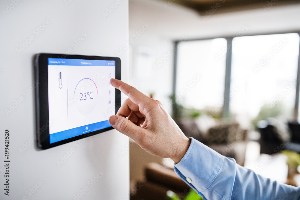 A man pointing to a tablet with smart home screen. A man pointing to a tablet with smart home screen.