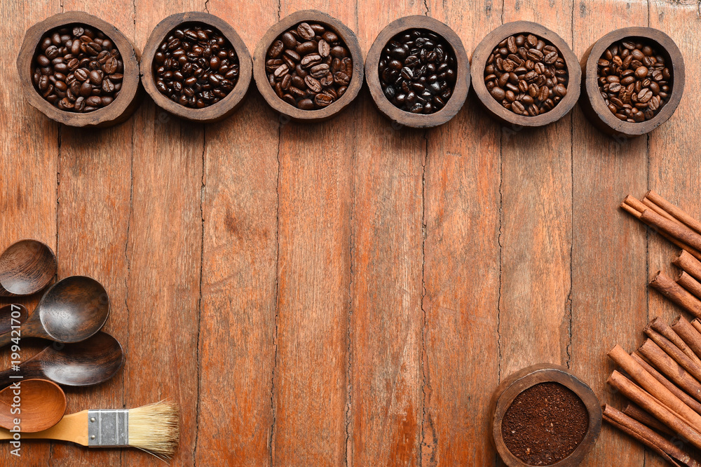 Close up of coffee beans in wooden bowl and cinnamon Close up of coffee beans in wooden bowl and cinnamon