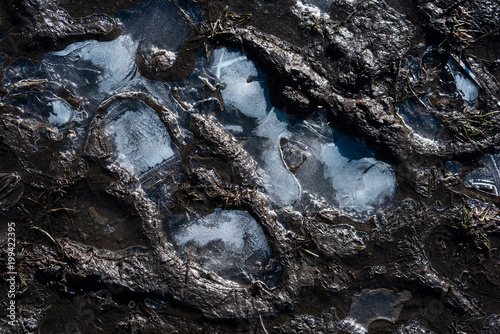 Frozen footprints of shoes in the mud on top close, the concept of tourism