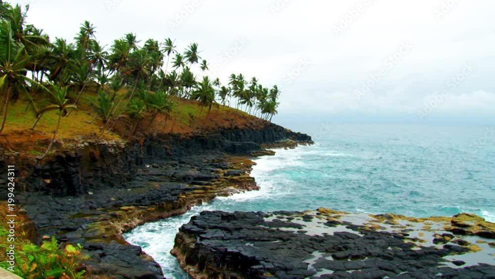 Rough waves crash into a rocky shoreline in a wide angle landscape shot before a storm rolls in from the ocean Rough waves crash into a rocky shoreline in a wide angle landscape shot before a storm rolls in from the ocean