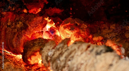 View into a fireplace with close up of a blazing burning logs.