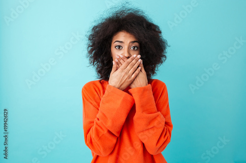 Tablou pe pânză Image of shocked woman 20s in casual clothing looking on camera and covering ope