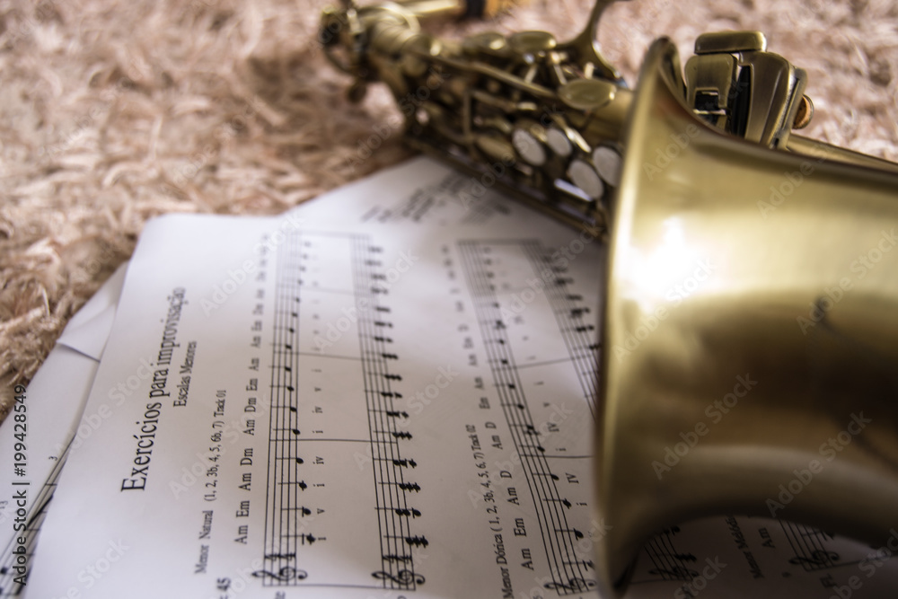 Naklejka premium Saxophone over music sheet