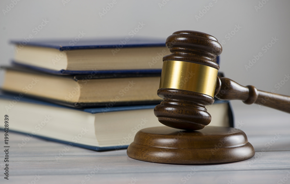 Wooden mallet used by a judge or at an auction next to a book. Concept Wooden mallet used by a judge or at an auction next to a book. Concept