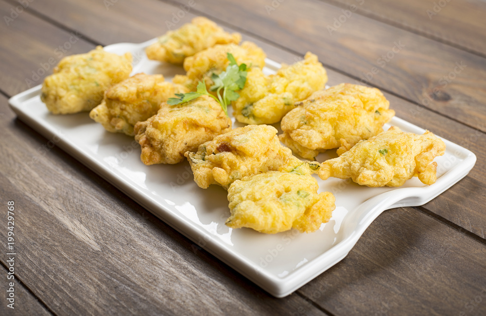 Cod fritters on brown wooden table. Spanish food. Cod fritters on brown wooden table. Spanish food.