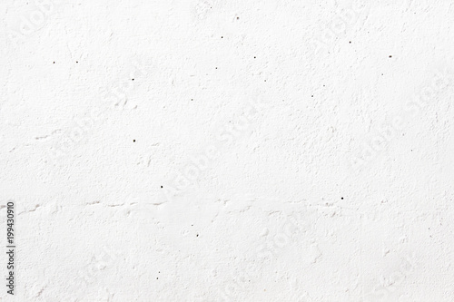 The texture of an old white wall painted with paint, on a bright spring sunny day
