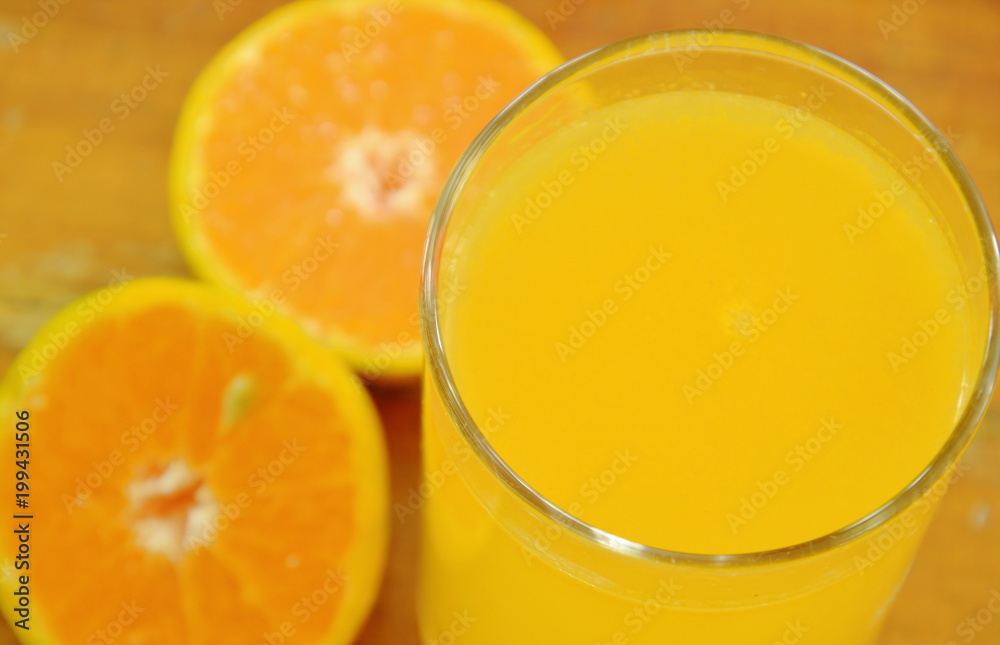 orange juice in glass and tangerine cutting on wooden board orange juice in glass and tangerine cutting on wooden board