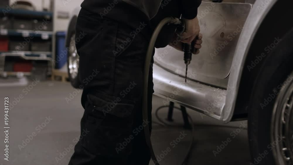 Car manufacturing plant engineers working on vehicles Car manufacturing plant engineers working on vehicles