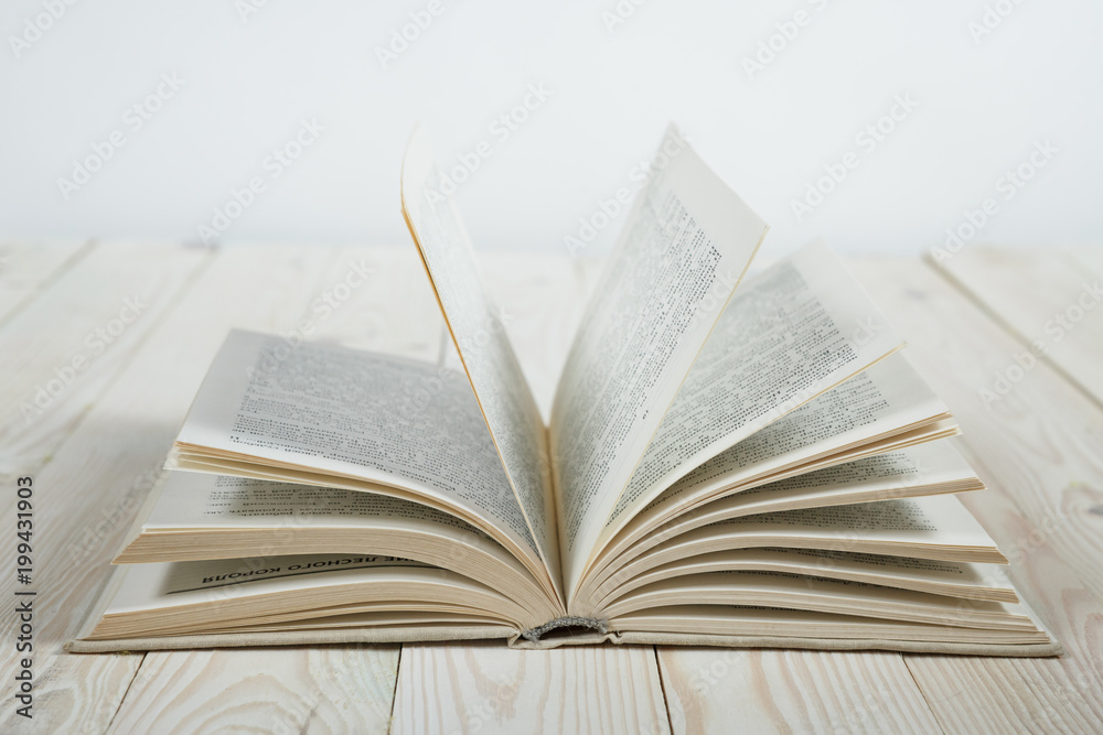 Open of pastel colorsbooks hardback on wooden table. Copy space. Selective focus. Knowledge concept Open of pastel colorsbooks hardback on wooden table. Copy space. Selective focus. Knowledge concept