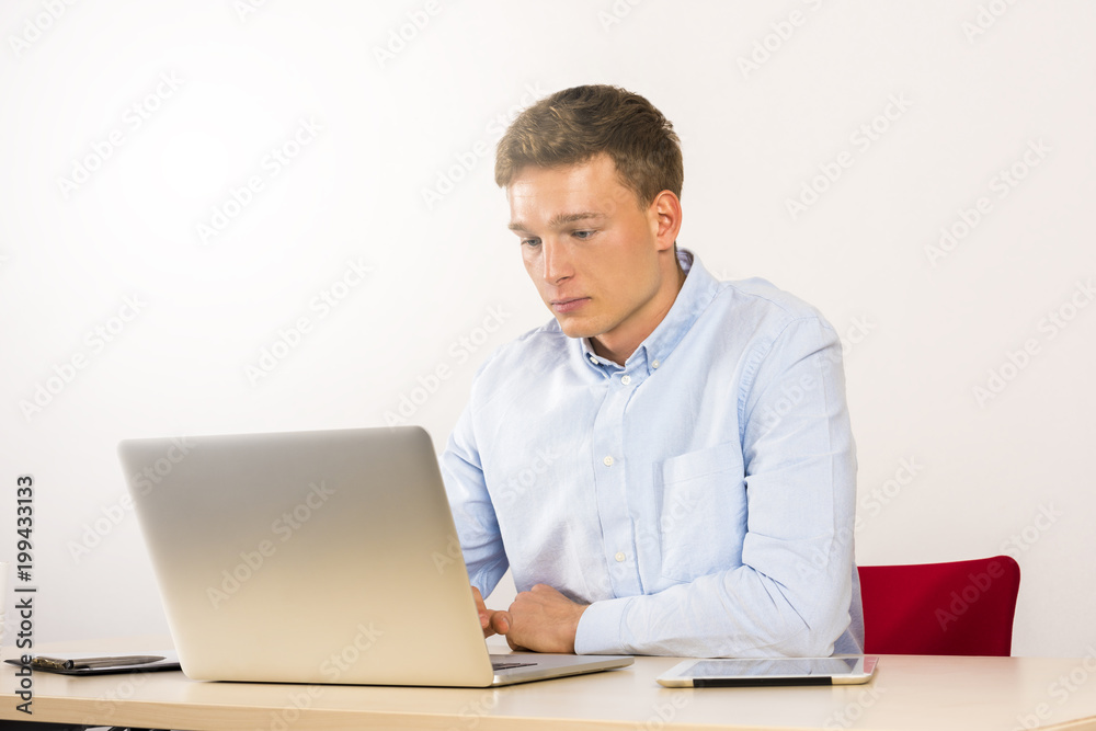 Office worker using computer on table, male caucasian young. Office worker using computer on table, male caucasian young.