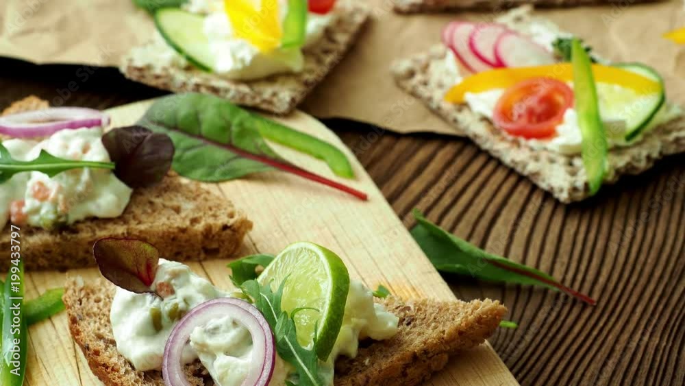 Healthy sandwiches with fresh vegetables. Breakfast toasts on wooden cutting board. Balanced breakfast. Healthy sandwiches with fresh vegetables. Breakfast toasts on wooden cutting board. Balanced breakfast.
