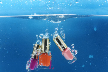 Leinwandbilder Nagelstudio Nagellackflaschen unter Wasser mit Luftblasen  © be free