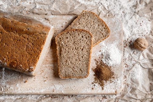 Rye bread on malt and flour, lies on the table. Near a pinch of flour and malt. photo