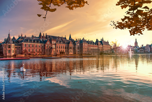 Sunset on the Binnenhof building and The Hague city reflected on the pond with a swan swimming on, Netherlands