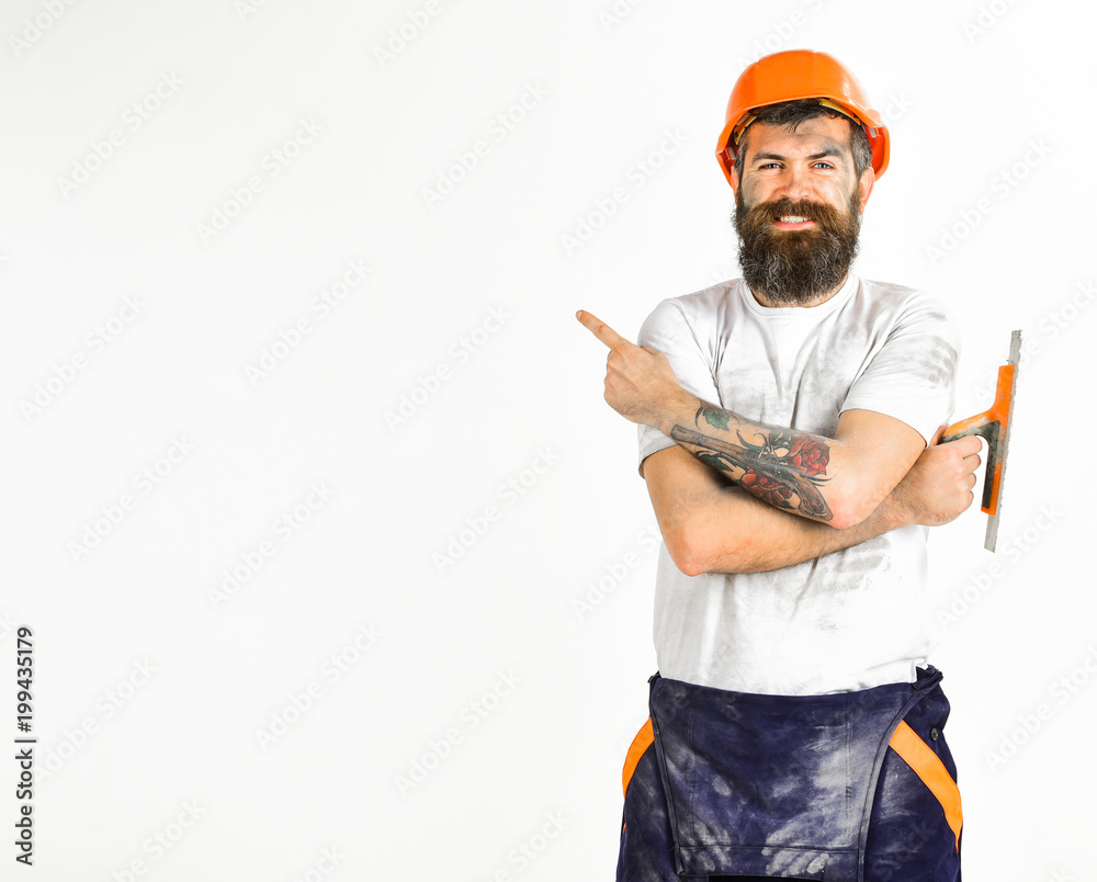 Man with smile holds putty knife or tool Man with smile holds putty knife or tool
