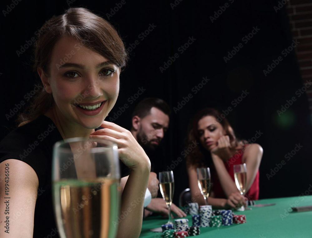 portrait of smiling woman with drink playing poker