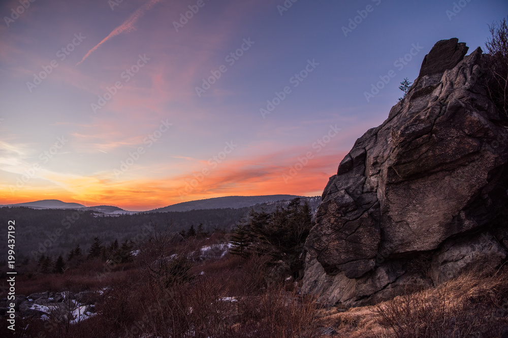 Sunset falling behind rock