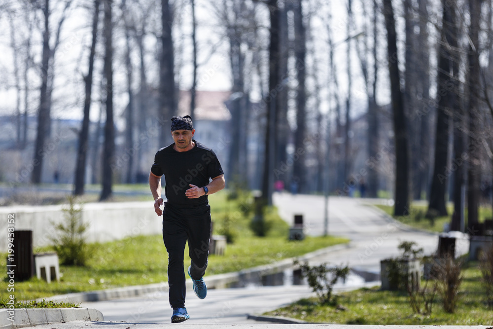 A middle-aged man running through the park