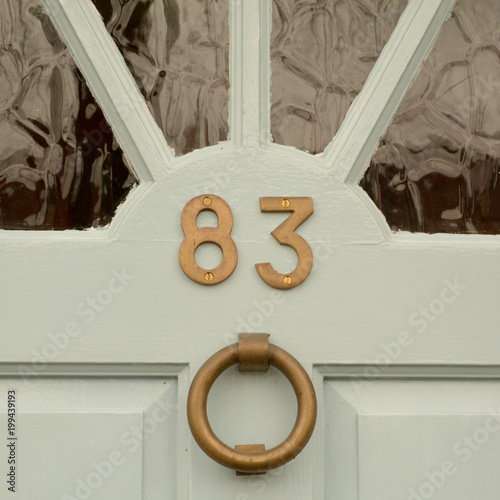 House number 83 sign on door with brass door knocker