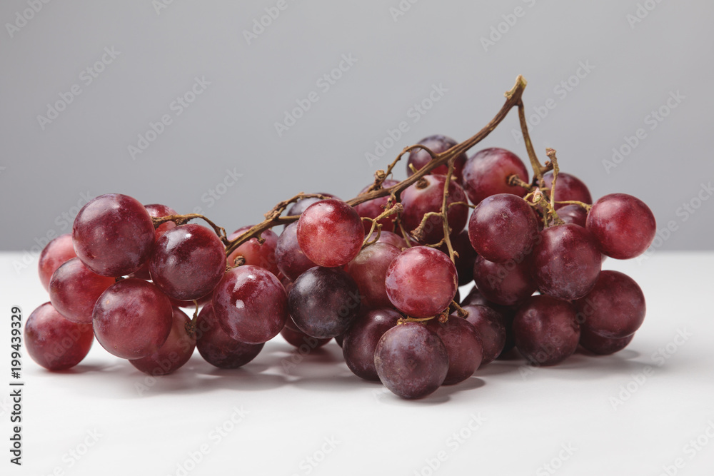 Close up view of pile of red grapes on gray Close up view of pile of red grapes on gray