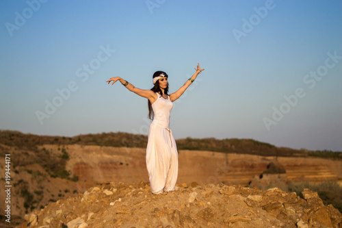 Girl in white clothes dancing Oriental dance in nature. Relaxation. Mountainous terrain.